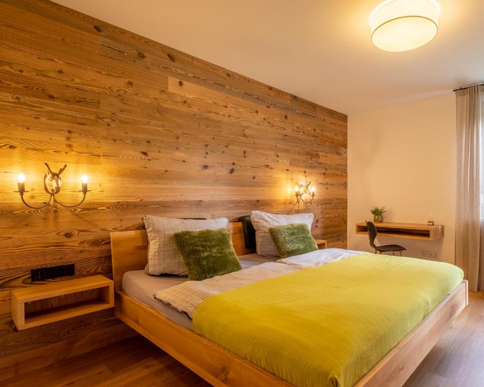 una camera con un letto e una parete in legno di Ferienwohnung Alpenzeit a Oberstaufen