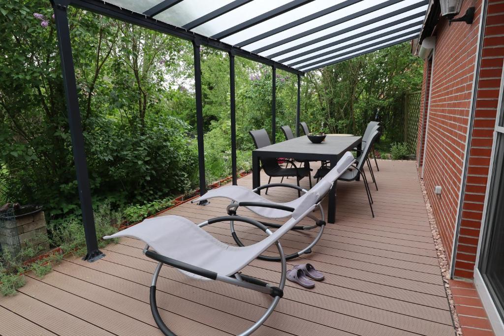 a patio with a table and chairs on a deck at Haus Flieder in Krummhörn