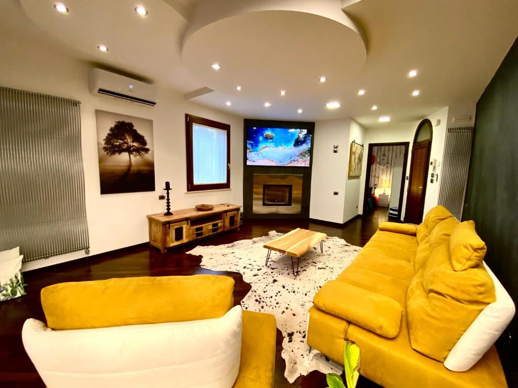 a living room with a yellow couch and a table at Wood Luxury House in Pescara