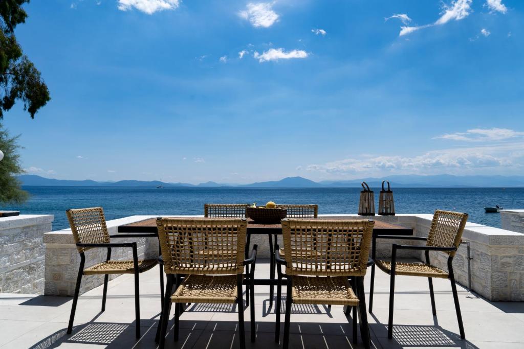 patio ze stołem i krzesłami oraz widokiem na ocean w obiekcie Gatzeas Blue w mieście Kato Gatzea