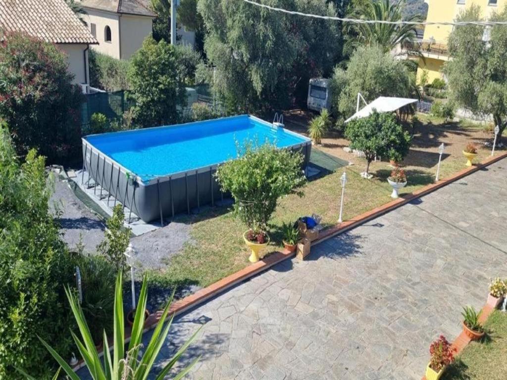 a large swimming pool in a yard with plants at VILLA FELICE in Loano