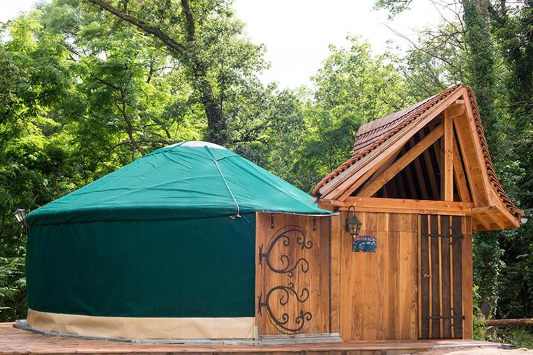 a wooden out house with a green tent at Yourte La Désirade in Semur-en-Auxois