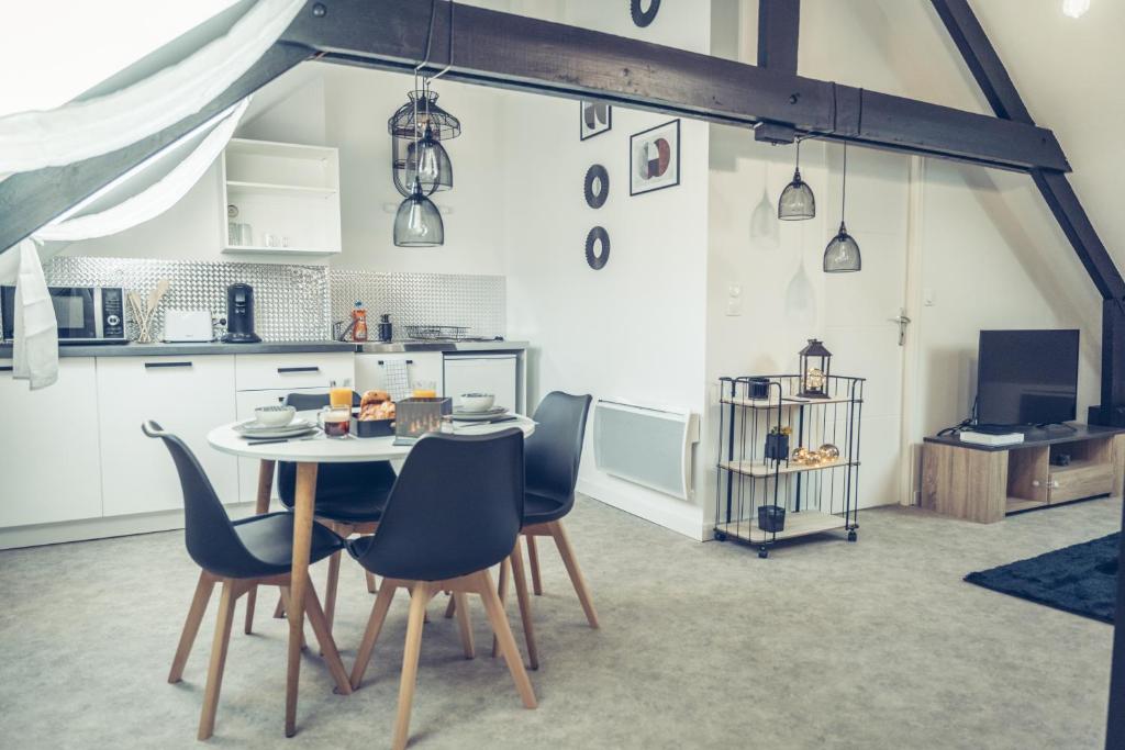 - une cuisine et une salle à manger avec une table et des chaises dans l'établissement Le loft superbe studio avec stationnement gratuit, à Dunkerque