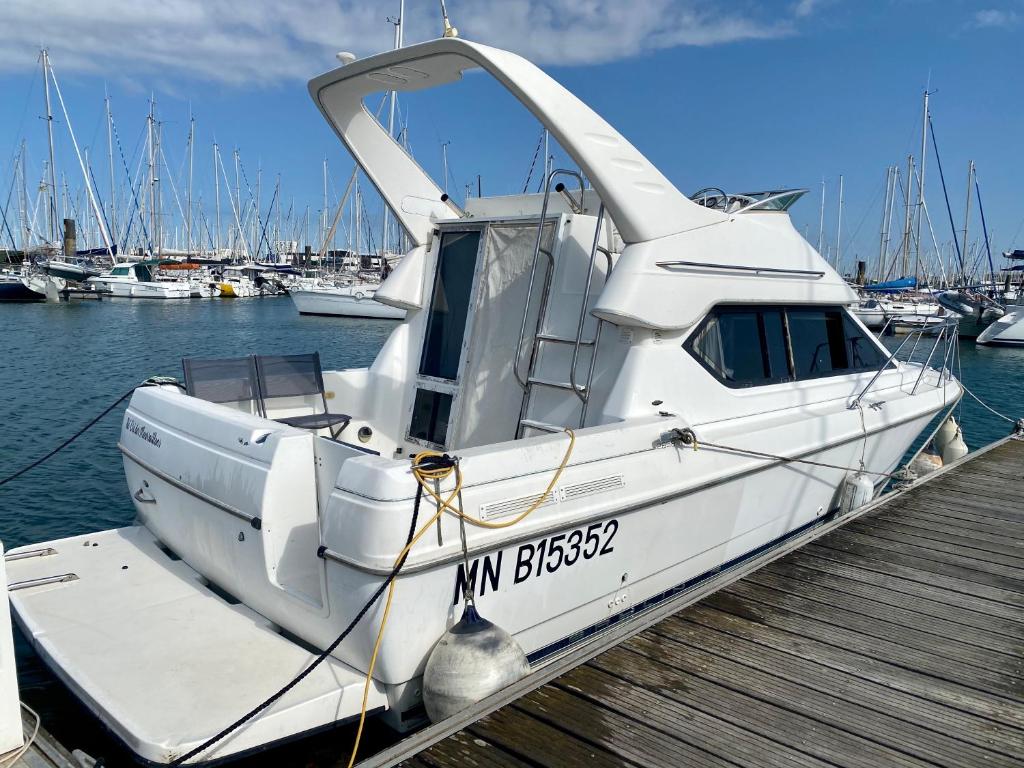a white boat is docked at a dock at Nuit insolite sur un bateau - Linge & ménage inclus in La Rochelle