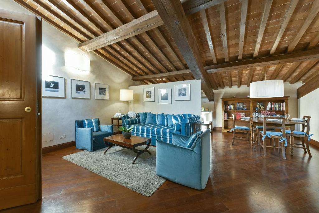 a living room with blue chairs and a table at Tiepolo romantic penthouse in the Oltrarno in Florence