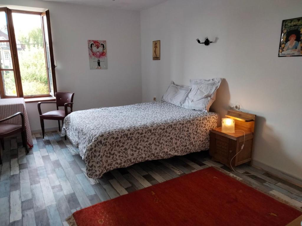 a bedroom with a bed and a table and a window at La Petite Auberge in Lorquin