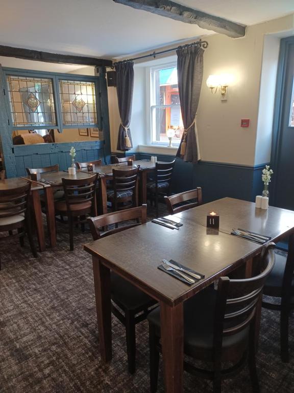 a dining room with wooden tables and chairs at George Hotel in Keswick