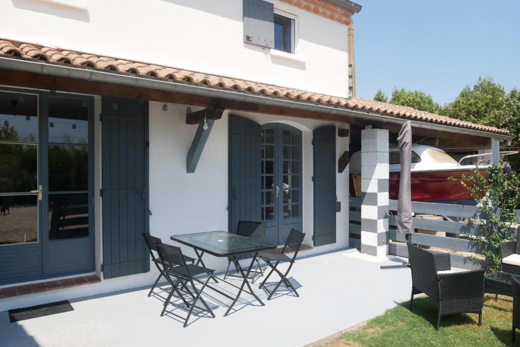 patio ze stołem i krzesłami przed domem w obiekcie La Petite Maison w mieście Arles