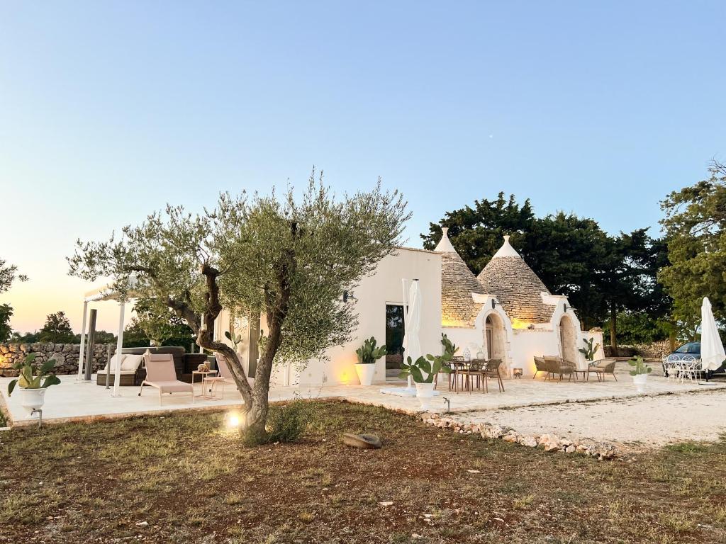 a house with a tree in the middle of a yard at EnjoyTrulli - Countryside in Noci