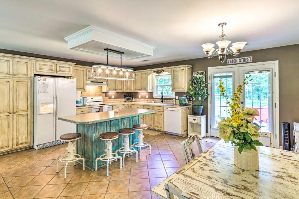 a kitchen with wooden cabinets and a table with stools at Higden Home with Furnished Porch, Spacious Yard in Fairfield Bay
