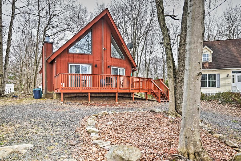 ein großes rotes Haus mit einer großen Terrasse in der Unterkunft Golf, Ski and Fish Cabin with Deck in Tobyhanna! in Tobyhanna