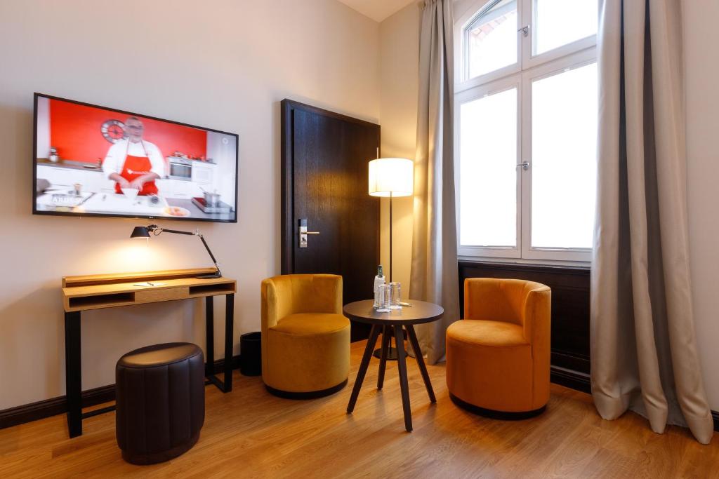 a room with a table and two chairs and a tv at Hotel Alte Post in Konstanz