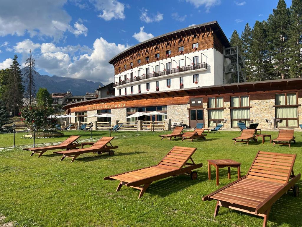 a group of benches in front of a building at Chaberton Lodge & Spa in Sauze dʼOulx