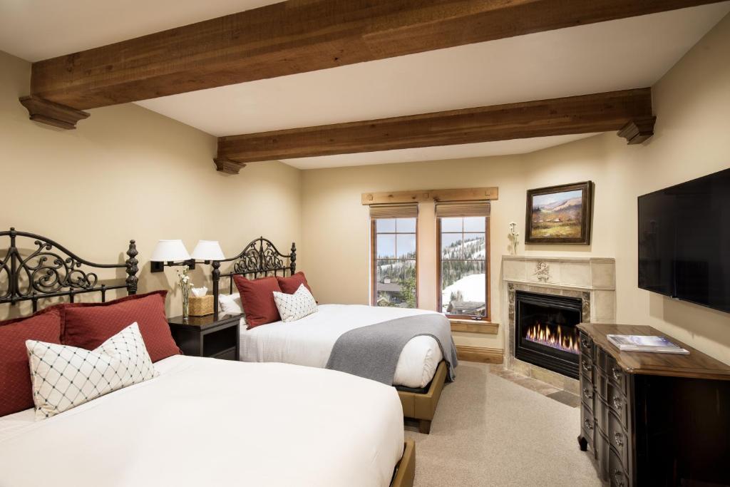 two beds in a room with a fireplace at Hotel 2 Queen Hotel Room in Park City