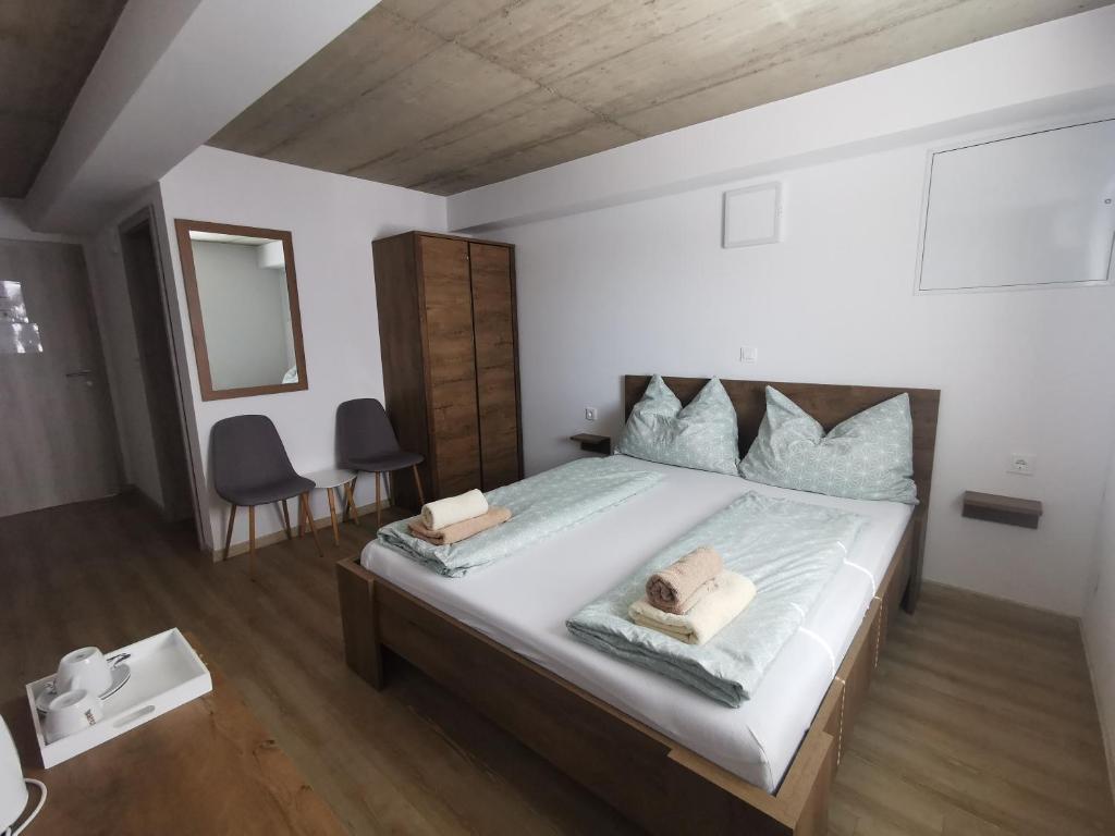 a bedroom with a large bed with two towels on it at Sobe, Rooms B&B - Vina Kauran in Zgornji Jakobski Dol