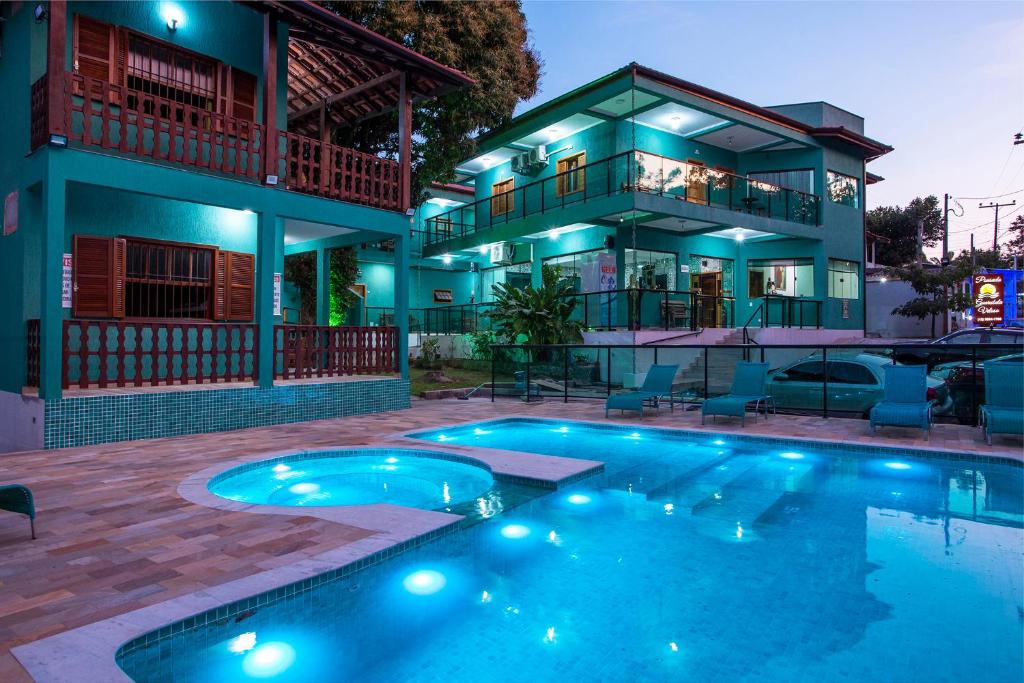 una casa con piscina frente a una casa en Pousada Guarubela Veloso, en Ilhabela