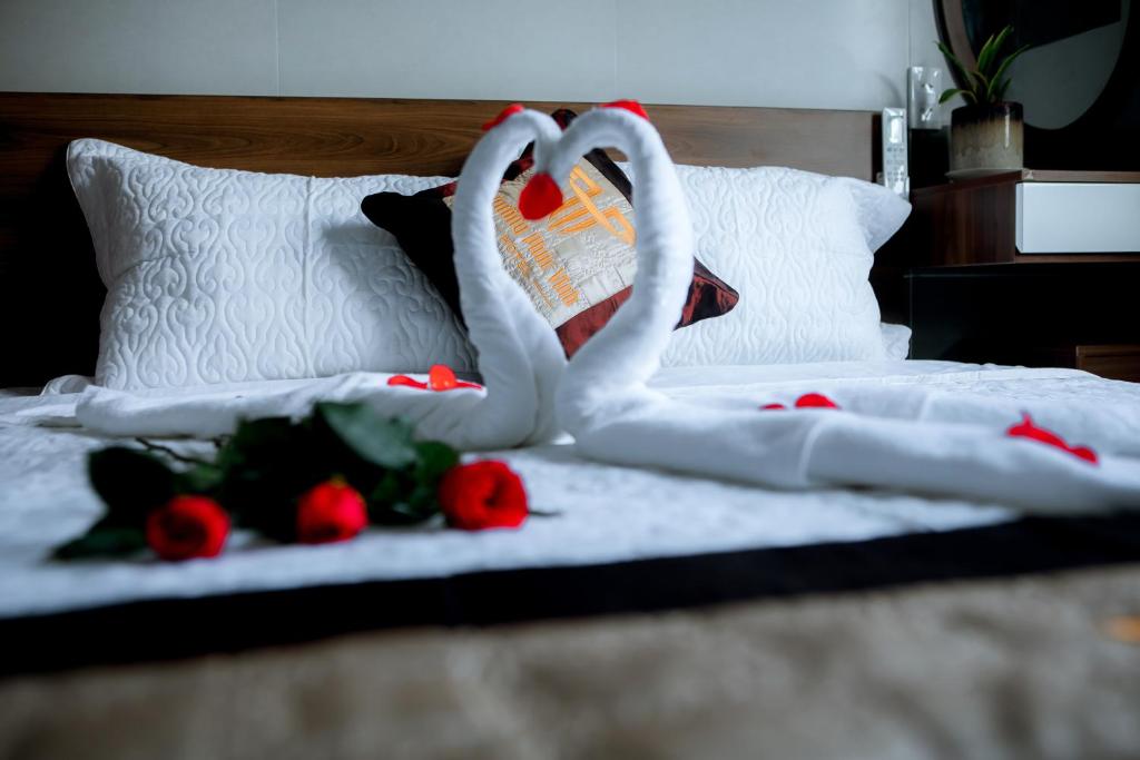 two swans making a heart on a bed with roses at Trường Phúc Vinh Hotel in Phan Thiet