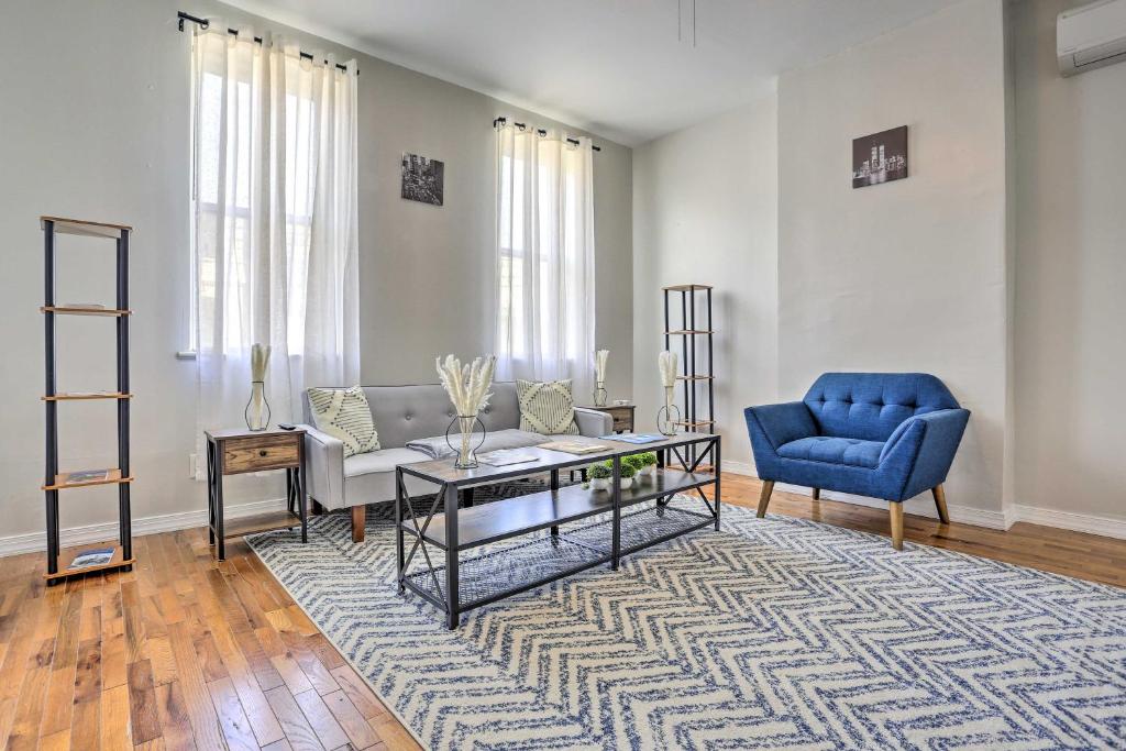 a living room with a couch and a blue chair at Updated Bayonne Townhome about 11 Mi to NYC! in Bayonne