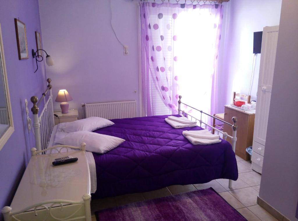 ein violettes Bett in einem Schlafzimmer mit einem Fenster in der Unterkunft Hera Hotel in Nafplio