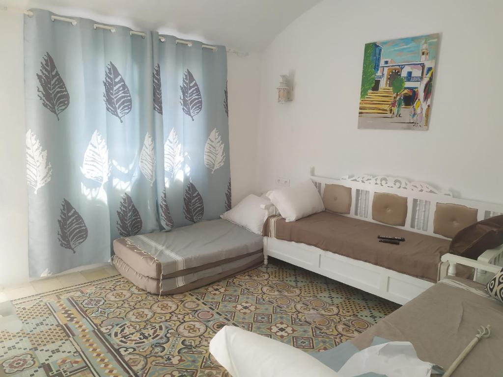 a room with two beds and a couch in it at Dar Fatma in Hammamet