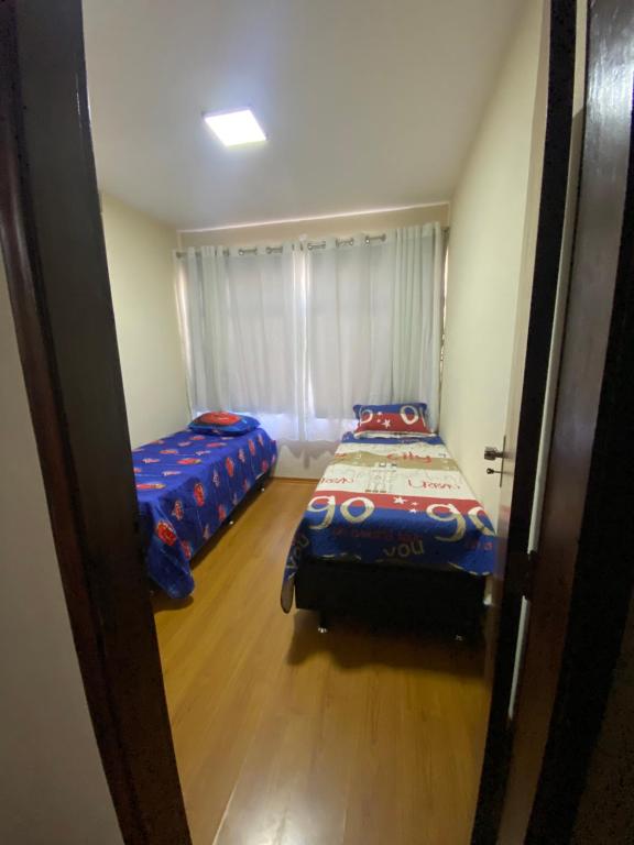 a bedroom with two beds and a window at Apto com garagem no centro de Nova Friburgo in Nova Friburgo