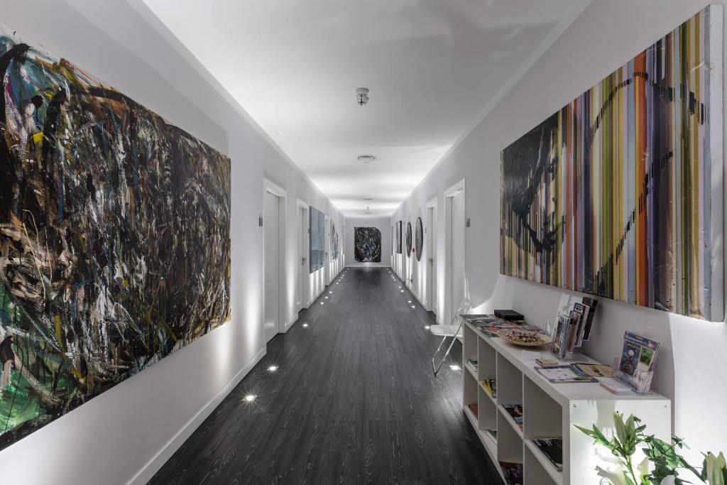 a hallway with paintings on the walls at Studio Inn De Angeli in Milan