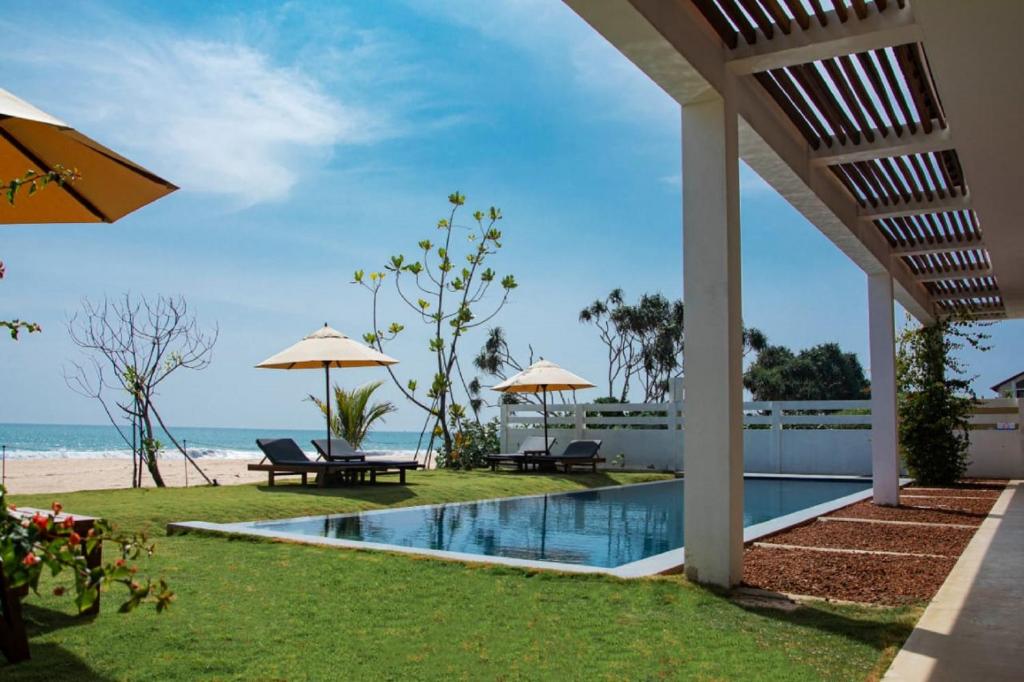 a view of the beach from the backyard of a villa at Villa Tanderra in Tangalle