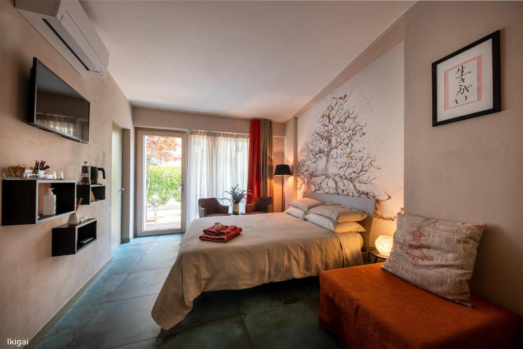 ein Schlafzimmer mit einem Bett, einem Fenster und einem Stuhl in der Unterkunft San Francesco Guest House in Savigliano