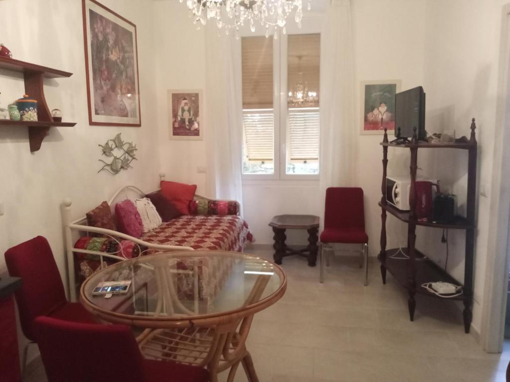 un soggiorno con divano e tavolo in vetro di La Corte di Paola 1 e 2 a Genova
