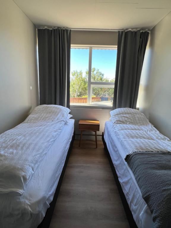 2 Betten in einem Zimmer mit Fenster in der Unterkunft Stykkishólmur house in Stykkishólmur