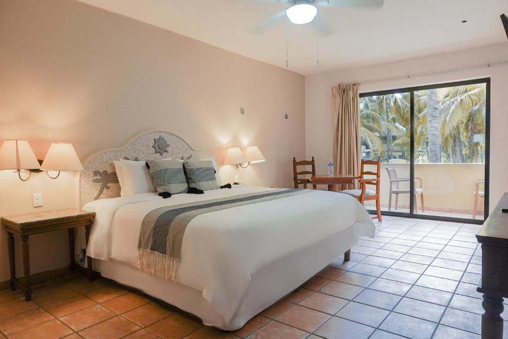 特爾切港的住宿－尤卡坦礁石全包酒店及會議中心，一间带大床的卧室和一个阳台