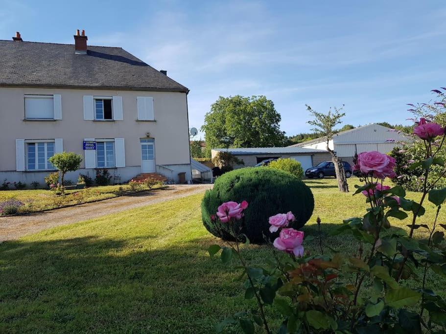 a house with a green yard with pink roses at Maison de maître à 2 pas du lac des Settons in Montsauche