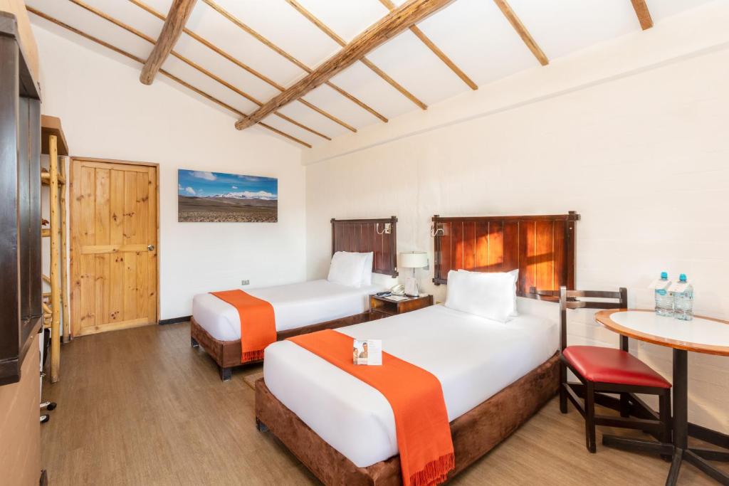 una habitación de hotel con dos camas y una mesa en Casa Andina Standard Colca, en Chivay