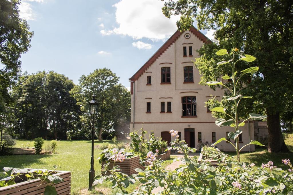 una casa antigua con un jardín delante de ella en Gutshaus Zarchlin en Zarchlin