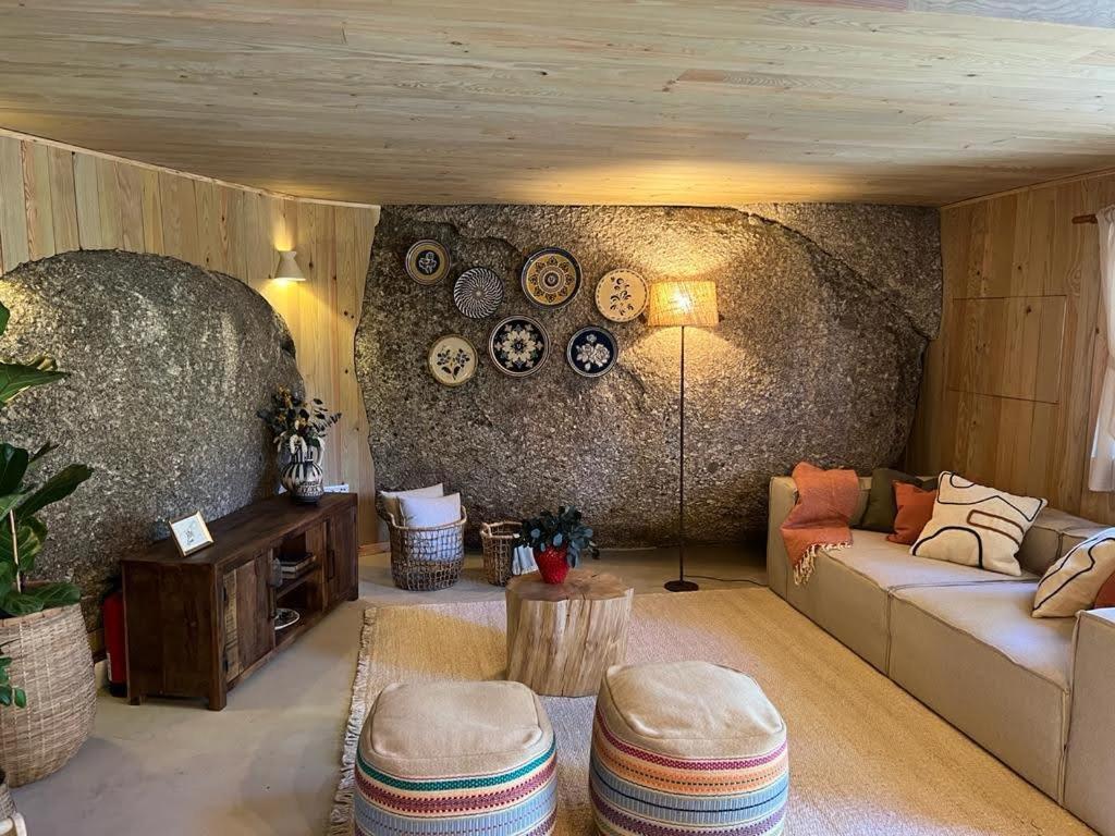 a living room with a couch and a stone wall at DiverLanhoso - Alojamento in Póvoa de Lanhoso