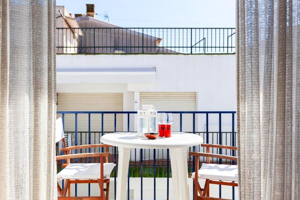 uma mesa branca com uma bebida na varanda em 3 bedrooms appartement with city view furnished terrace and wifi at Llafranc em Llafranc