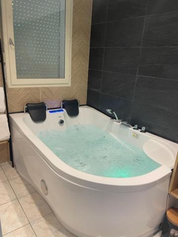 a bath tub with blue water in a bathroom at appart spa et mer in Bormes-les-Mimosas