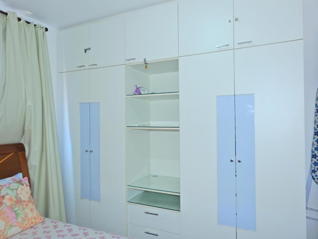 1 dormitorio con armarios blancos y 1 cama en Apartamento Vernazza Aconchegante, en Maceió