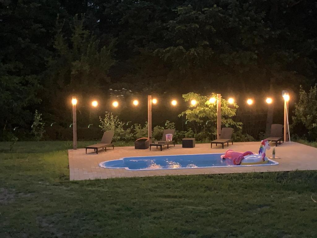 uma rapariga está deitada numa piscina à noite em Happiness Country Retreat em Bubel
