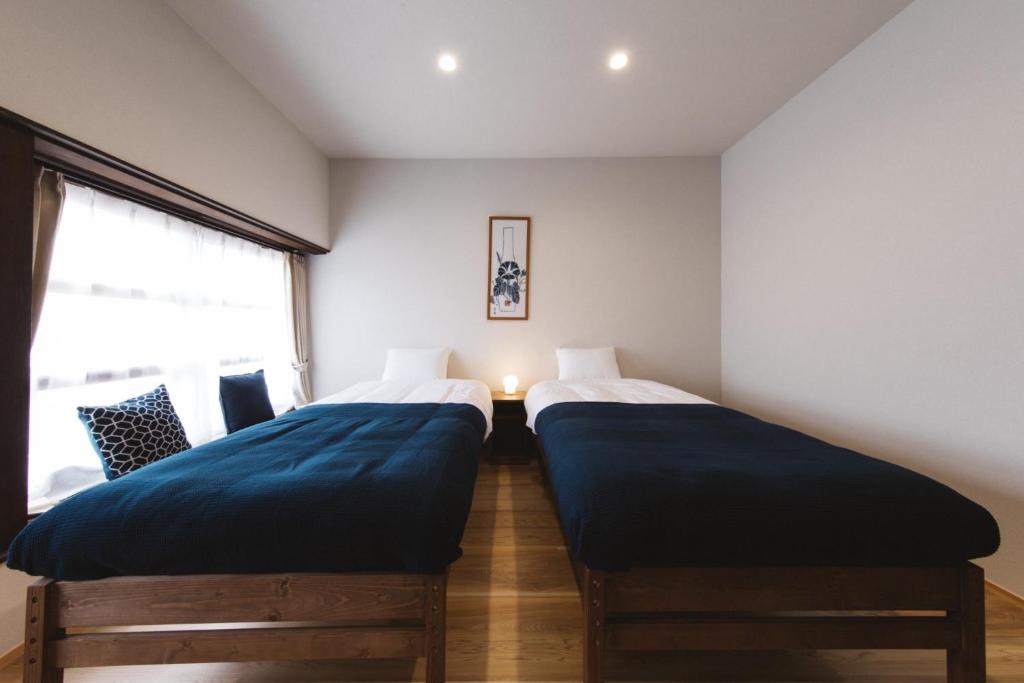 two beds sitting next to each other in a bedroom at Large family accommodation Tsuji family - Vacation STAY 11297v in Mitoyo