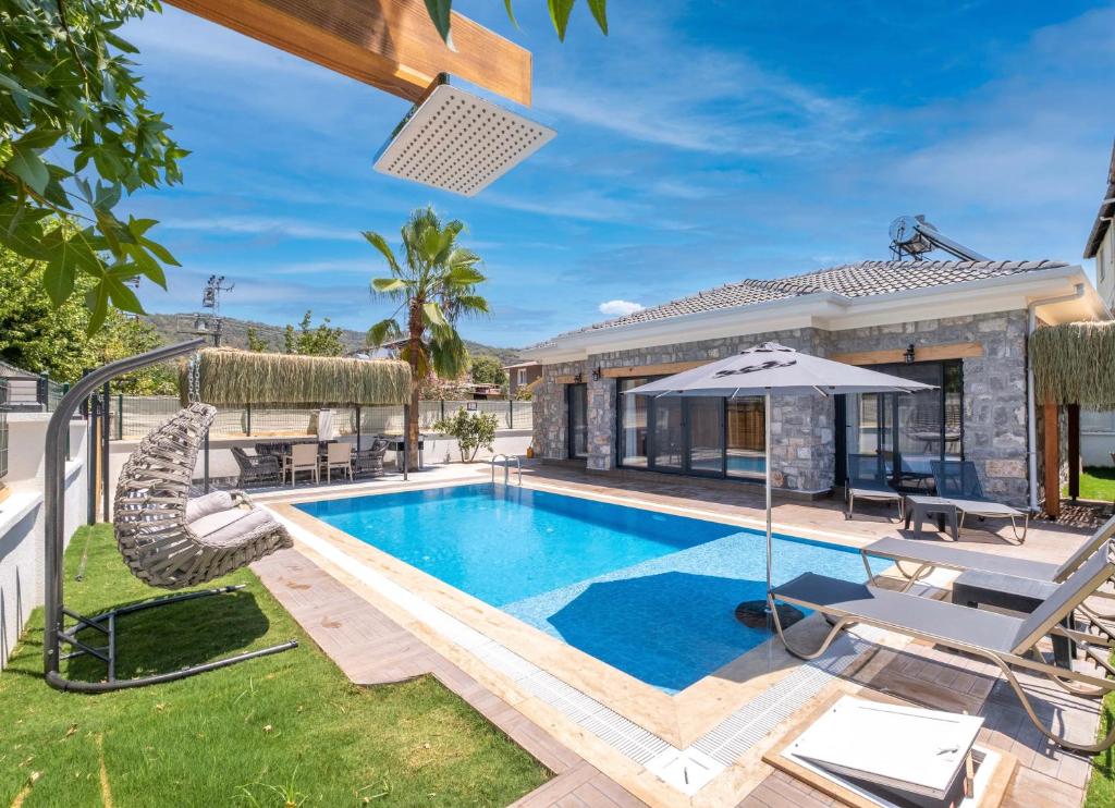 a swimming pool in the backyard of a house at Müstakil havuzlu jakuzili tatil villası in Fethiye