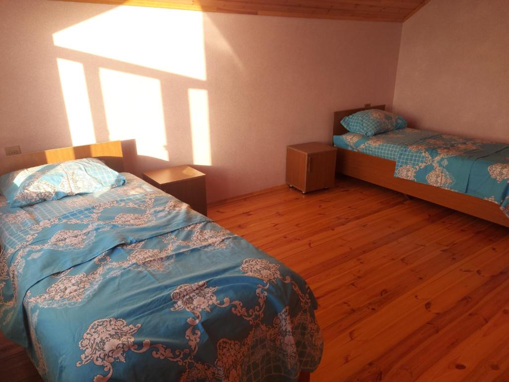 a bedroom with two beds and a window at SUNRISE Guest House in İsmayıllı
