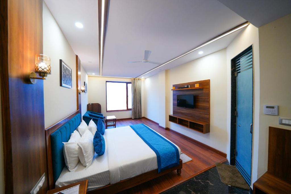 Habitación de hotel con cama y TV en The Abhyudyam Ganga en Haridwār