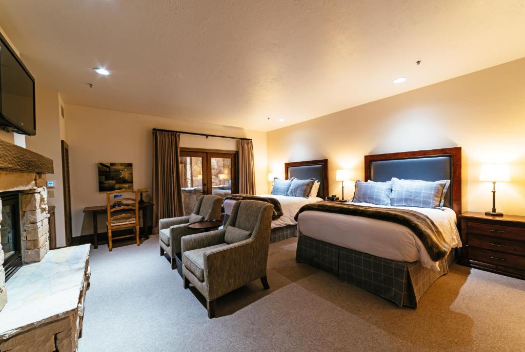 una camera d'albergo con due letti e un camino di Deluxe Two Queen Room with Fireplace Hotel Room a Park City