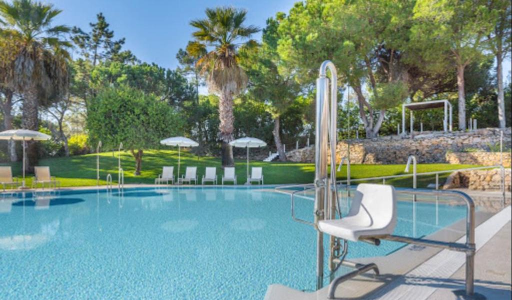 a large swimming pool with chairs and umbrellas at Quinta do Lago Golf, Sea & Sun in Quinta do Lago