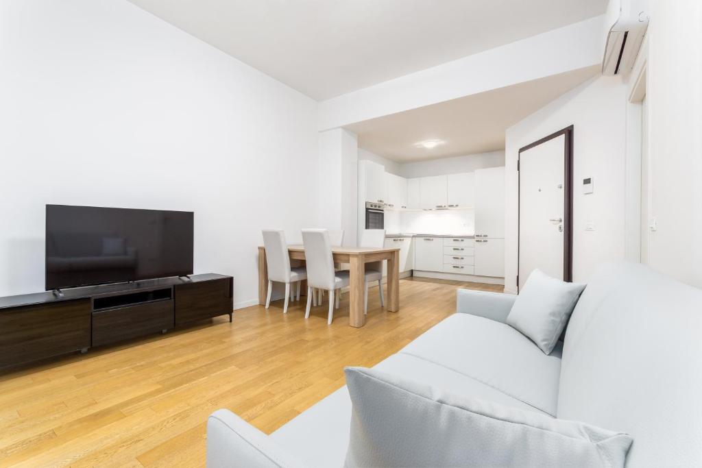 un soggiorno con divano, TV e tavolo di Casa da Suite Mirena a Milano