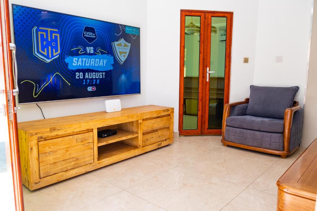 - un salon avec une télévision et une chaise dans l'établissement Gukurume- Gaborone, à Gaborone