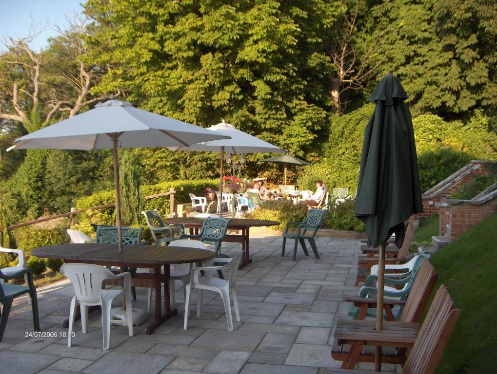 a patio table with chairs and umbrellas at Villa Rothsay Hotel in Cowes