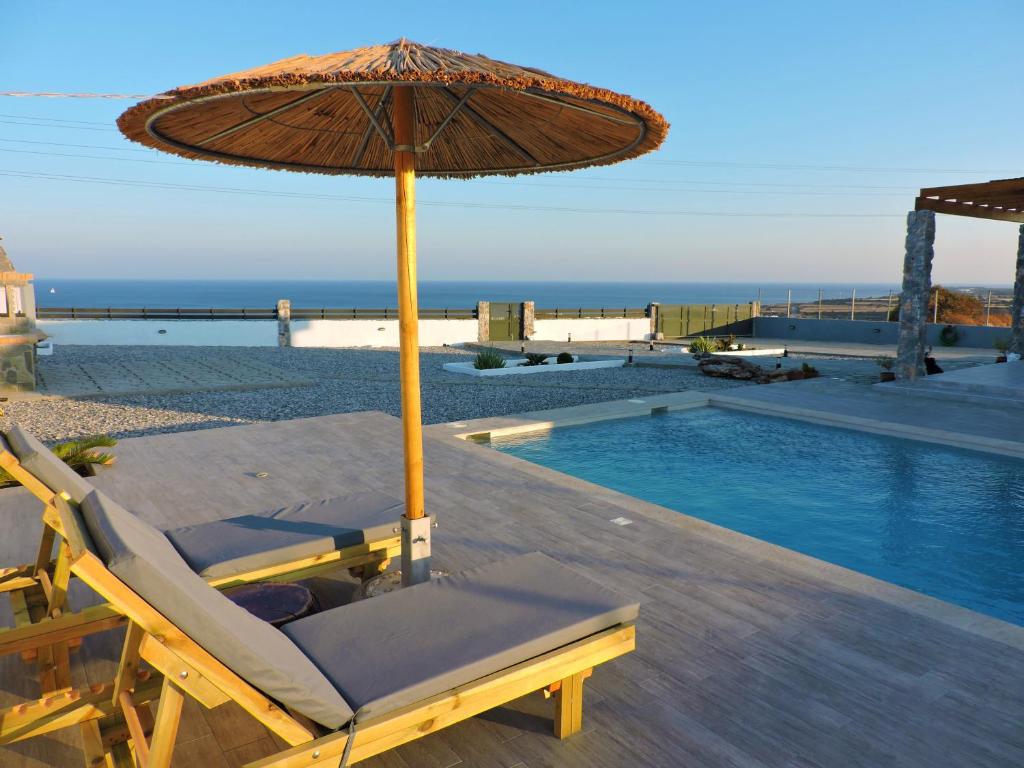 a chair with an umbrella next to a swimming pool at Onar Luxury Villa - Adults Only in Lachania