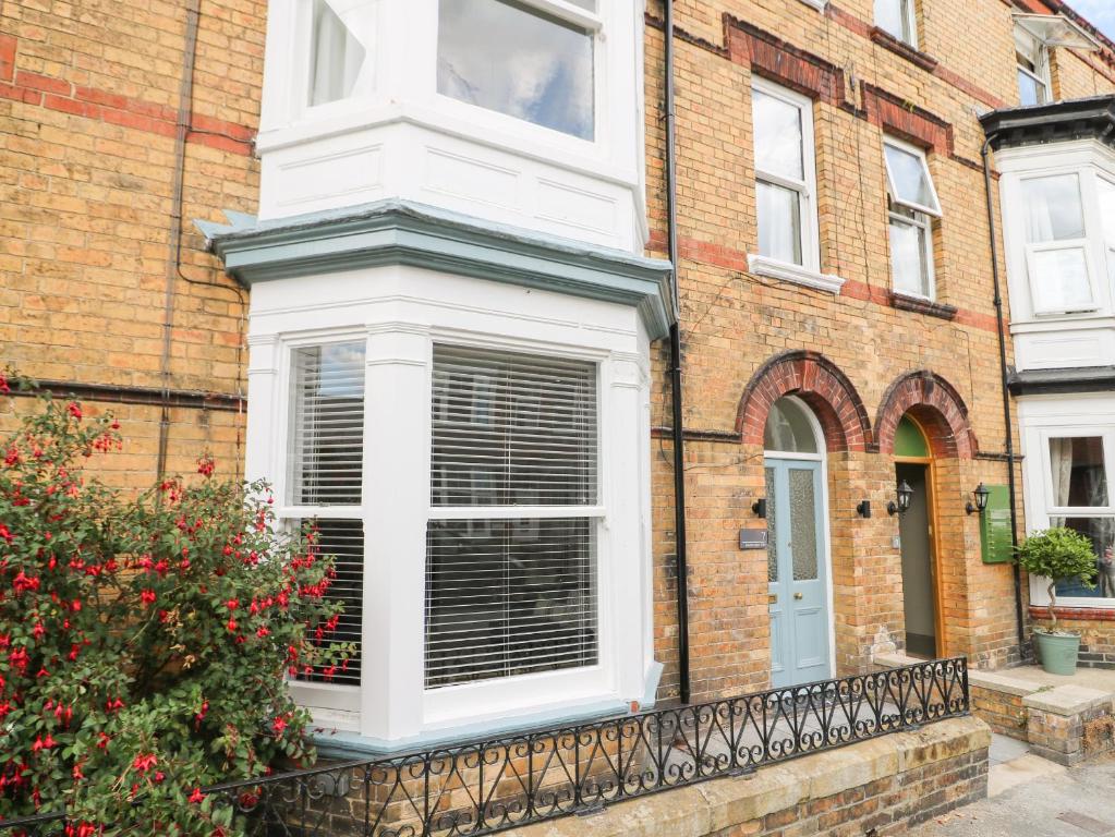 a white window on a brick house with a fence at Seascape Villa in Filey